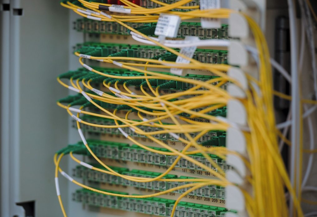 Cables de fibra óptica amarillos y verdes conectados de forma ordenada