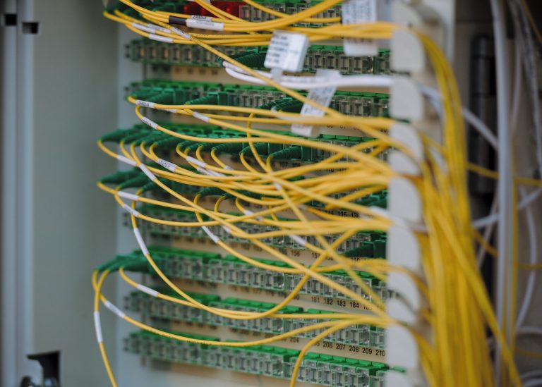 Cables de fibra óptica amarillos y verdes conectados de forma ordenada