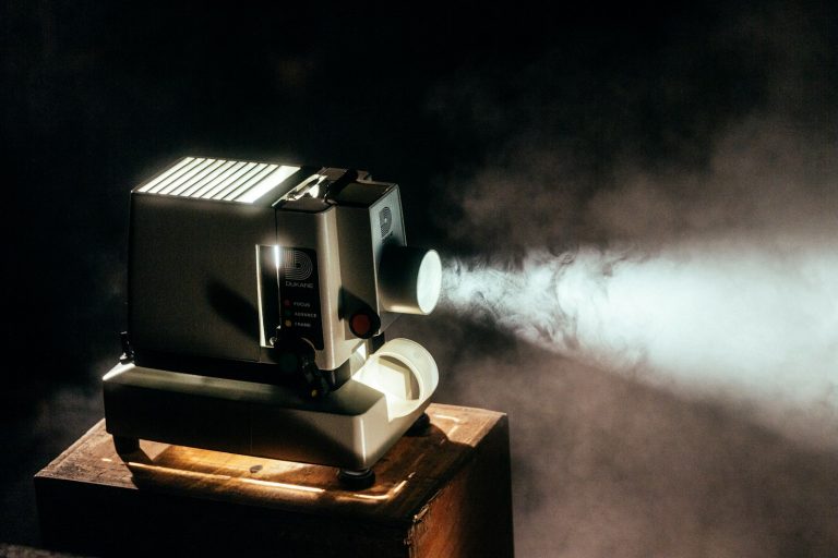 Proyector de cine encendido emitiendo un haz de luz en la oscuridad